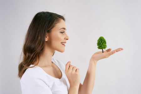 woman-holding-growing-tree-her-hand